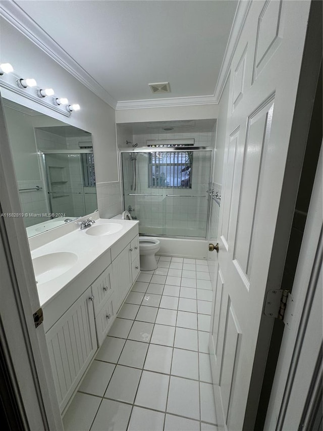 full bathroom with ornamental molding, vanity, enclosed tub / shower combo, tile patterned flooring, and toilet