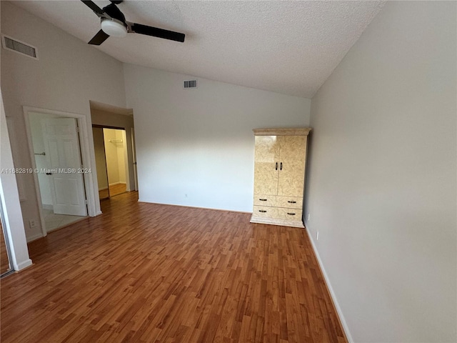 unfurnished bedroom with hardwood / wood-style floors, a textured ceiling, high vaulted ceiling, and ceiling fan