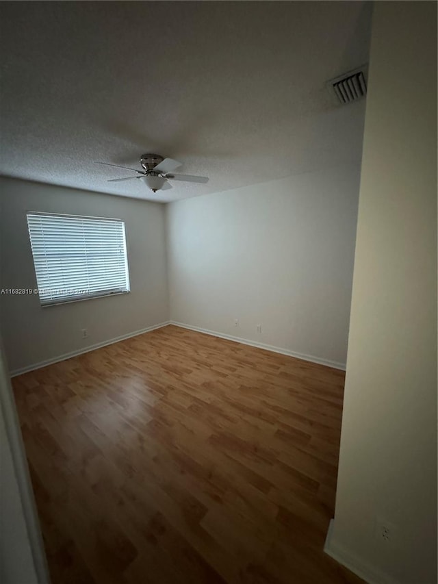 unfurnished room with ceiling fan and wood-type flooring