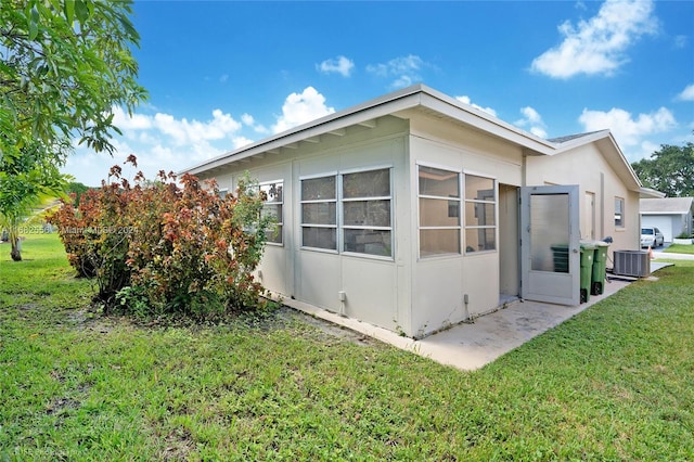 view of home's exterior featuring cooling unit, a yard, and a sunroom