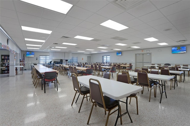 dining area with a paneled ceiling and a healthy amount of sunlight