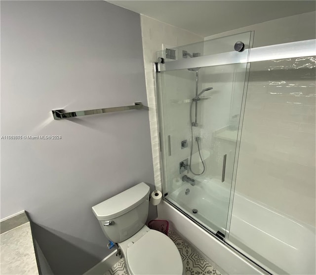 full bathroom featuring toilet, bath / shower combo with glass door, and vanity