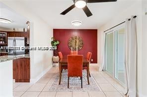 tiled dining space with ceiling fan