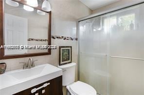 bathroom with vanity, toilet, and walk in shower