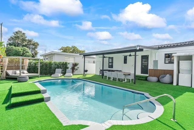 back of house with a yard, a pergola, a fenced in pool, and ceiling fan