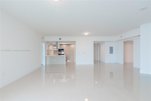 empty room with electric panel and light tile patterned flooring