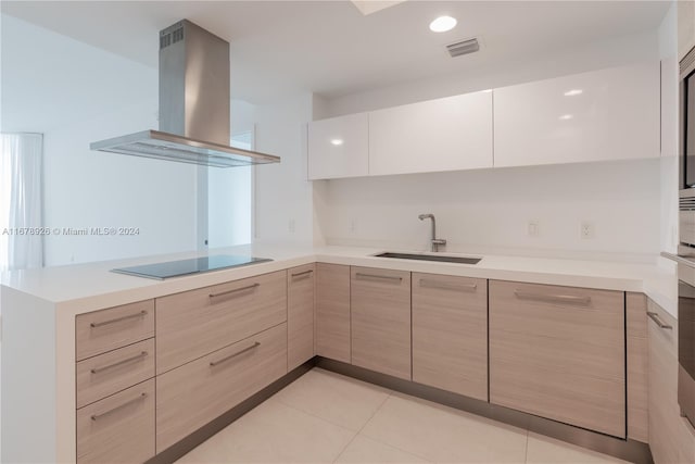 kitchen with light brown cabinets, light tile patterned floors, black electric cooktop, wall chimney exhaust hood, and sink