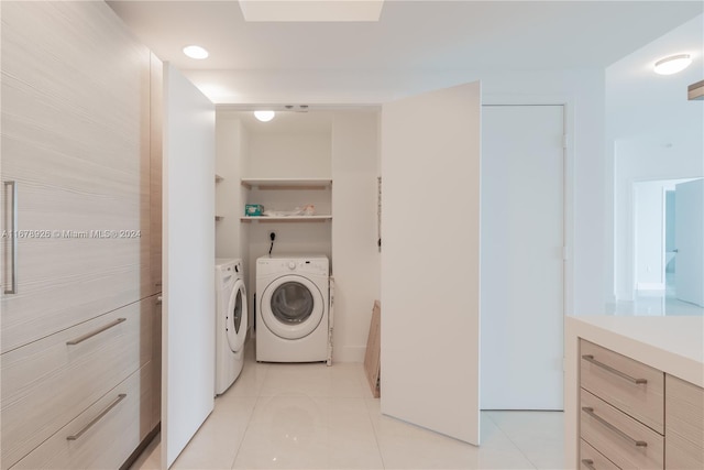 laundry area with light tile patterned flooring and washing machine and clothes dryer