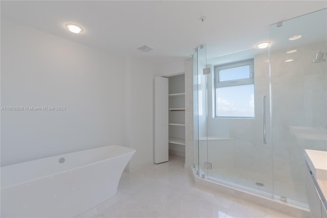 bathroom with vanity and shower with separate bathtub