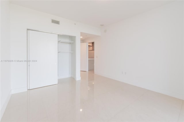 unfurnished bedroom featuring a closet and light tile patterned floors