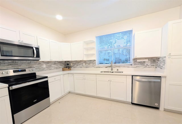 kitchen featuring a sink, backsplash, appliances with stainless steel finishes, and light countertops