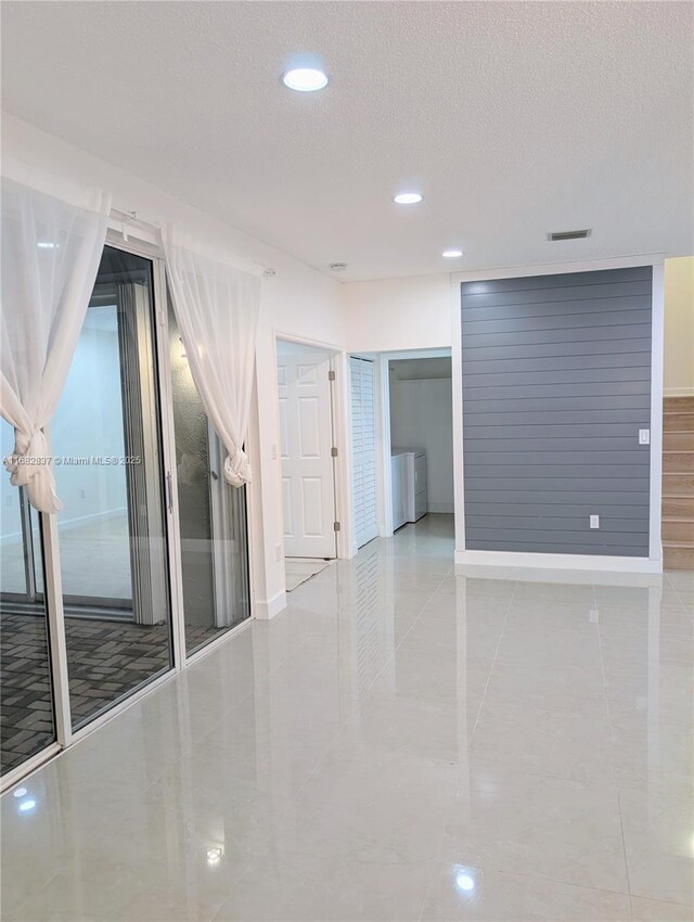 tiled empty room featuring a textured ceiling, sink, and a chandelier