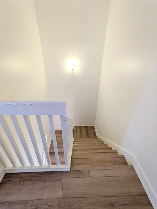 stairs with baseboards and wood finished floors