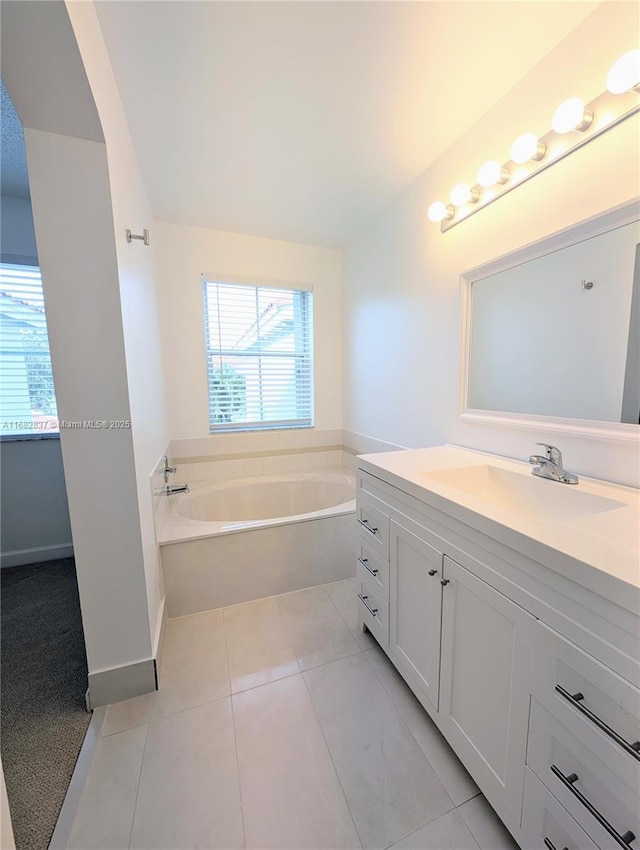 full bathroom with tile patterned floors, baseboards, a bath, and vanity