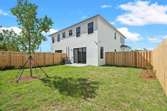 back of house with central AC and a lawn