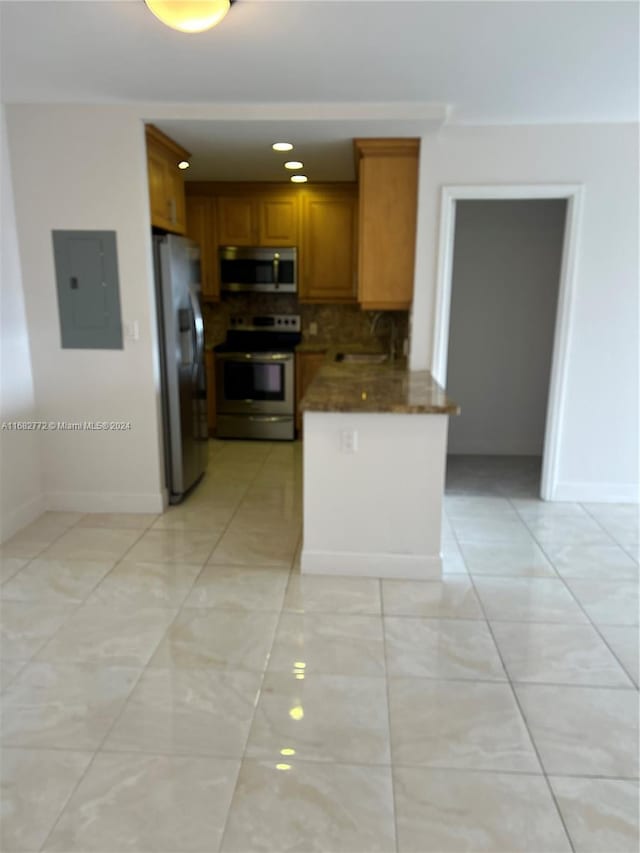 kitchen featuring sink, stainless steel appliances, tasteful backsplash, and electric panel