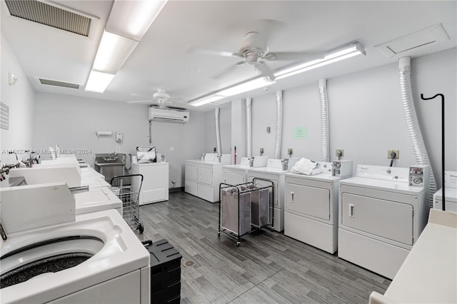 laundry area with ceiling fan, washer and dryer, a wall mounted air conditioner, light hardwood / wood-style flooring, and sink