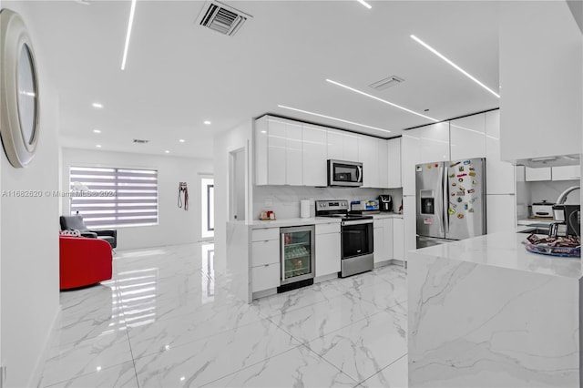 kitchen with stainless steel appliances, backsplash, wine cooler, sink, and white cabinetry