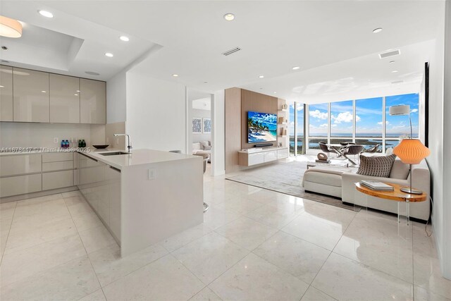 100 S Pointe Dr Unit 3402, Miami Beach, FL 33139 - kitchen with modern cabinets, expansive windows, a sink, open floor plan, and a peninsula