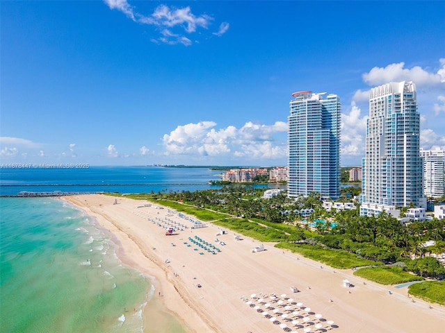 drone / aerial view featuring a water view and a beach view