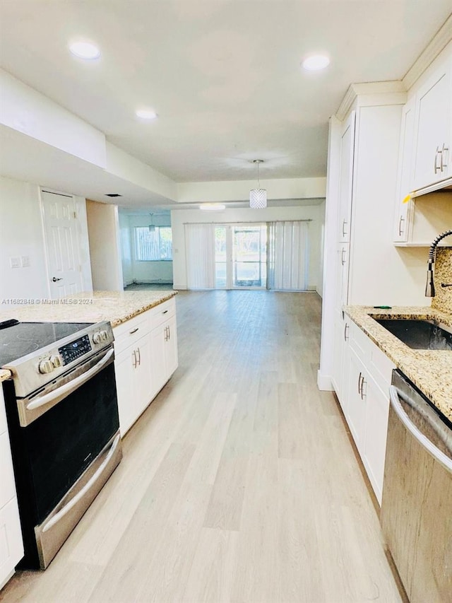 kitchen featuring white cabinetry, sink, light stone countertops, and stainless steel appliances