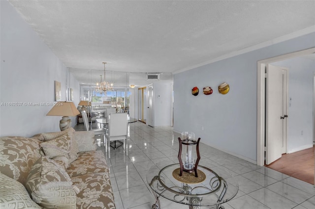 living room featuring a notable chandelier, a textured ceiling, light wood-type flooring, and crown molding