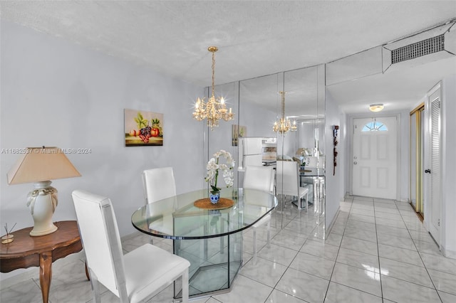 dining area featuring a chandelier and a textured ceiling