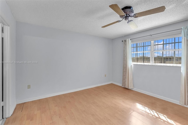 spare room featuring light hardwood / wood-style flooring, a textured ceiling, and ceiling fan