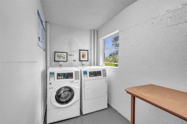 laundry area featuring washer and clothes dryer and a textured ceiling