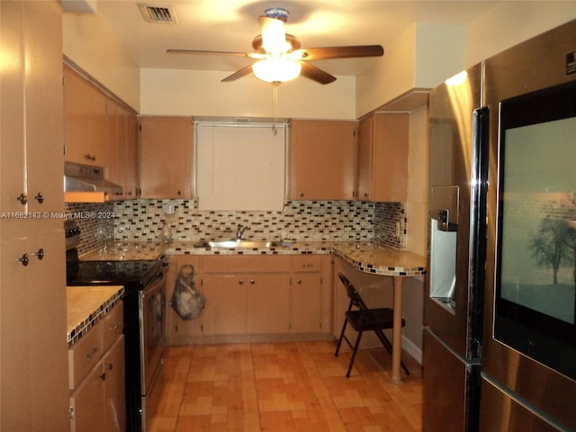 kitchen featuring appliances with stainless steel finishes, decorative backsplash, light brown cabinetry, and ceiling fan