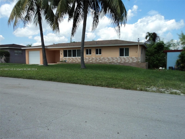 single story home with a front yard and a garage