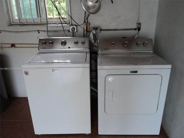 laundry room with washer and dryer and dark tile patterned floors