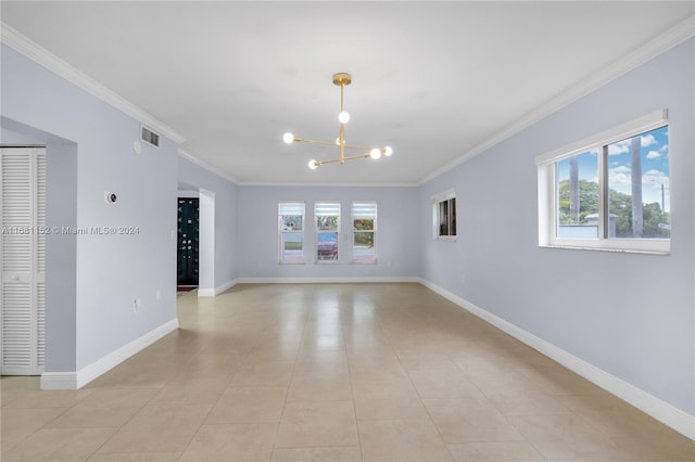 tiled spare room with crown molding and a chandelier