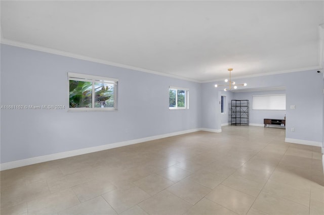 empty room featuring ornamental molding, light tile patterned floors, and a chandelier