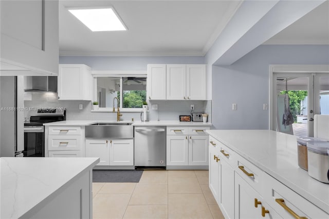 kitchen featuring appliances with stainless steel finishes, white cabinetry, tasteful backsplash, and sink