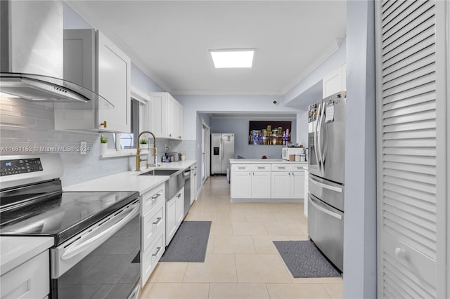 kitchen featuring sink, light tile patterned flooring, white cabinetry, stainless steel appliances, and wall chimney exhaust hood