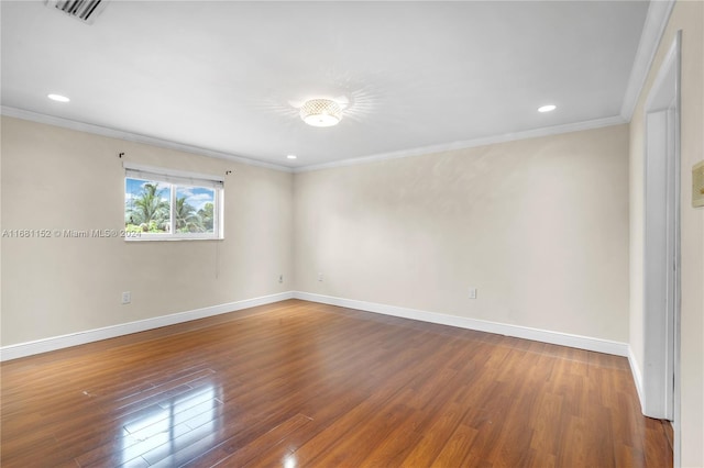 spare room with ornamental molding and hardwood / wood-style floors