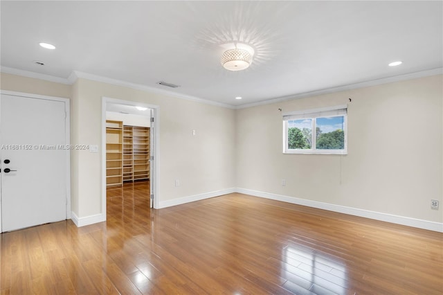 spare room with ornamental molding and light hardwood / wood-style flooring