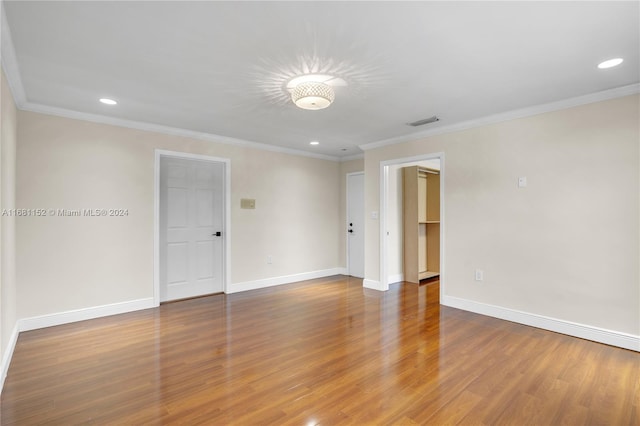 empty room with crown molding and wood-type flooring