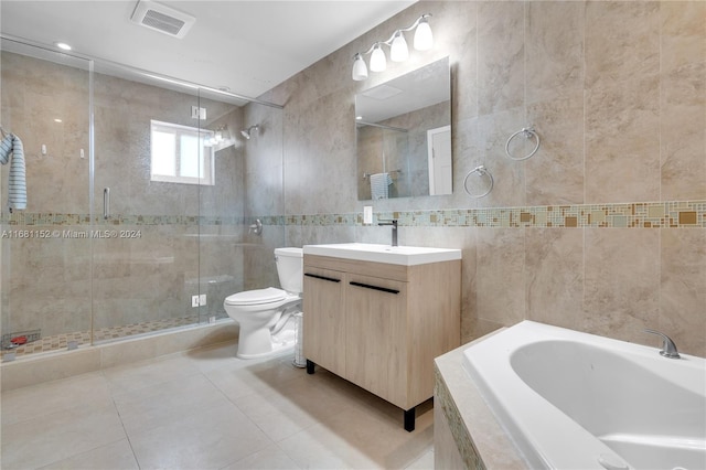 full bathroom with vanity, toilet, tile walls, and separate shower and tub