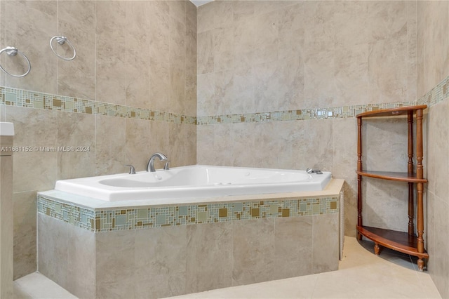 bathroom featuring tile walls, a relaxing tiled tub, and tile patterned flooring