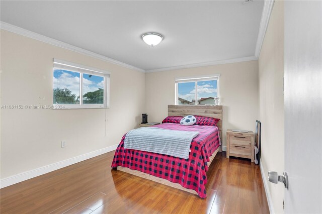 bedroom featuring hardwood / wood-style floors and crown molding