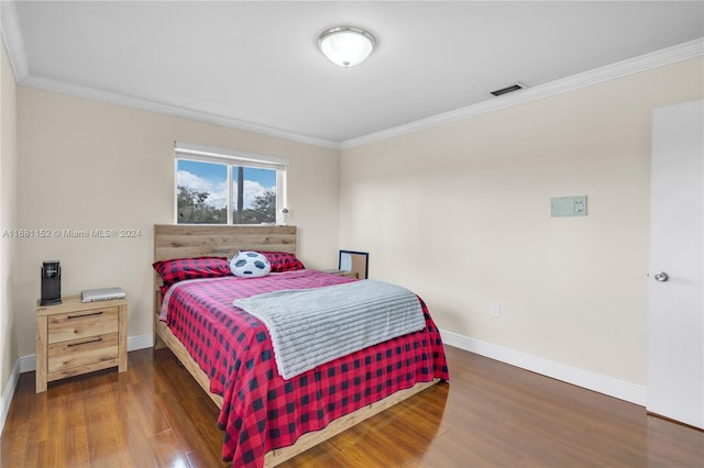 bedroom featuring crown molding and dark hardwood / wood-style floors