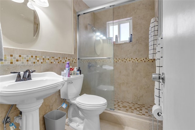 bathroom with toilet, an enclosed shower, tile walls, and tile patterned flooring