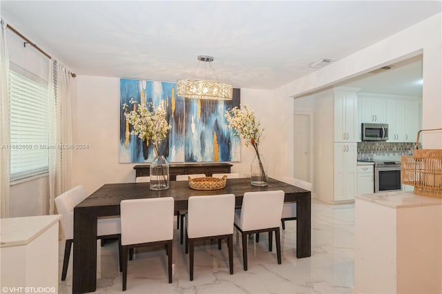8135 SW 136th St, Pinecrest, FL 33156 - dining space featuring light marble finish floors and a chandelier