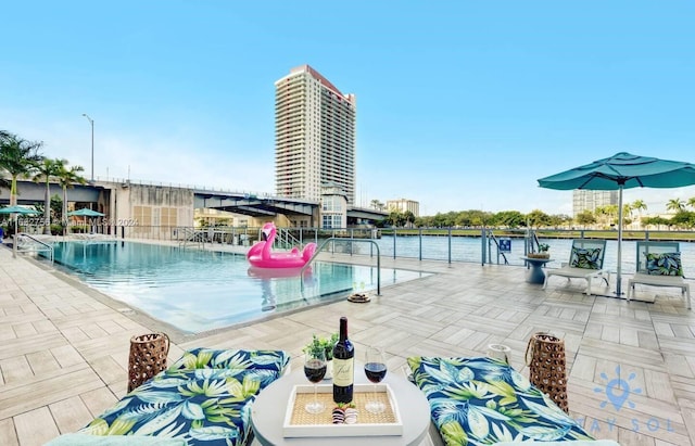 view of pool featuring a patio and a water view