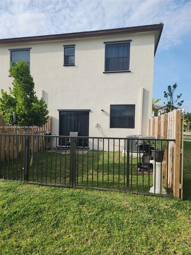 rear view of house featuring a yard