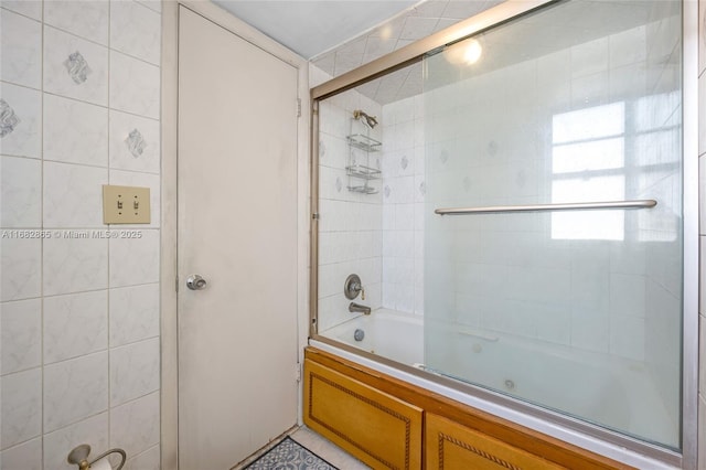 bathroom with tile patterned flooring and shower / bath combination with glass door