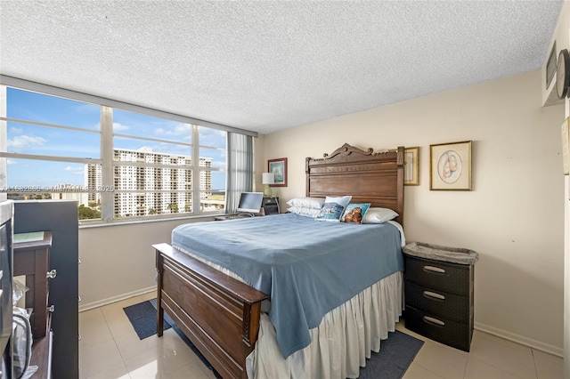 bedroom with a textured ceiling and light tile patterned floors