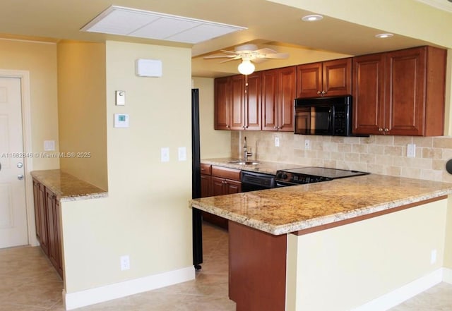 kitchen featuring light tile patterned floors, tasteful backsplash, a sink, a peninsula, and black appliances